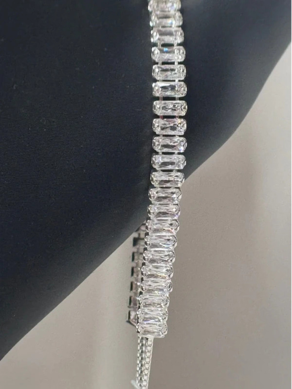 Adjustable tennis bracelet, emerald cut. Silver tone, cz
